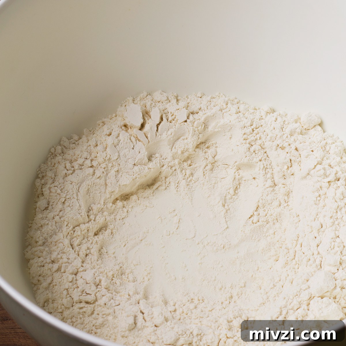 Homemade Pappardelle Recipe: Fresh Pasta from Scratch 5 Flour in a bowl with a well in the center for egg yolks.