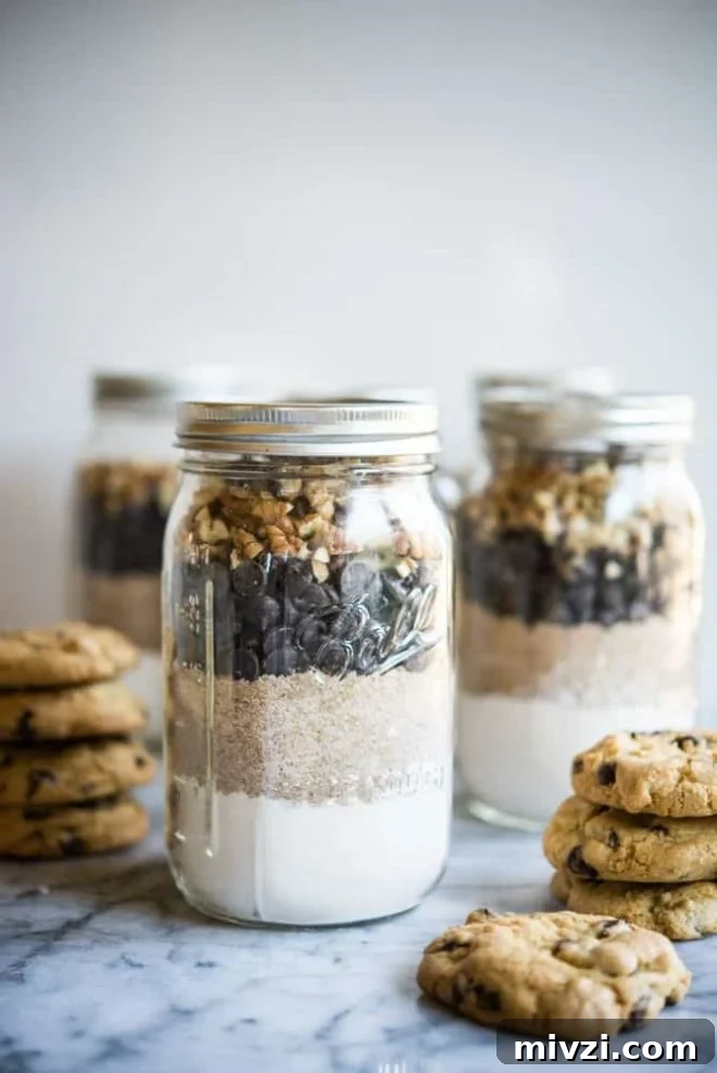 Gluten-Free Chocolate Chip Cookie Mix — Homemade Taste, Ready to Bake 2 Gluten free chocolate chip cookie mix in mason jars on a marble slab surrounded by chocolate chip cookies