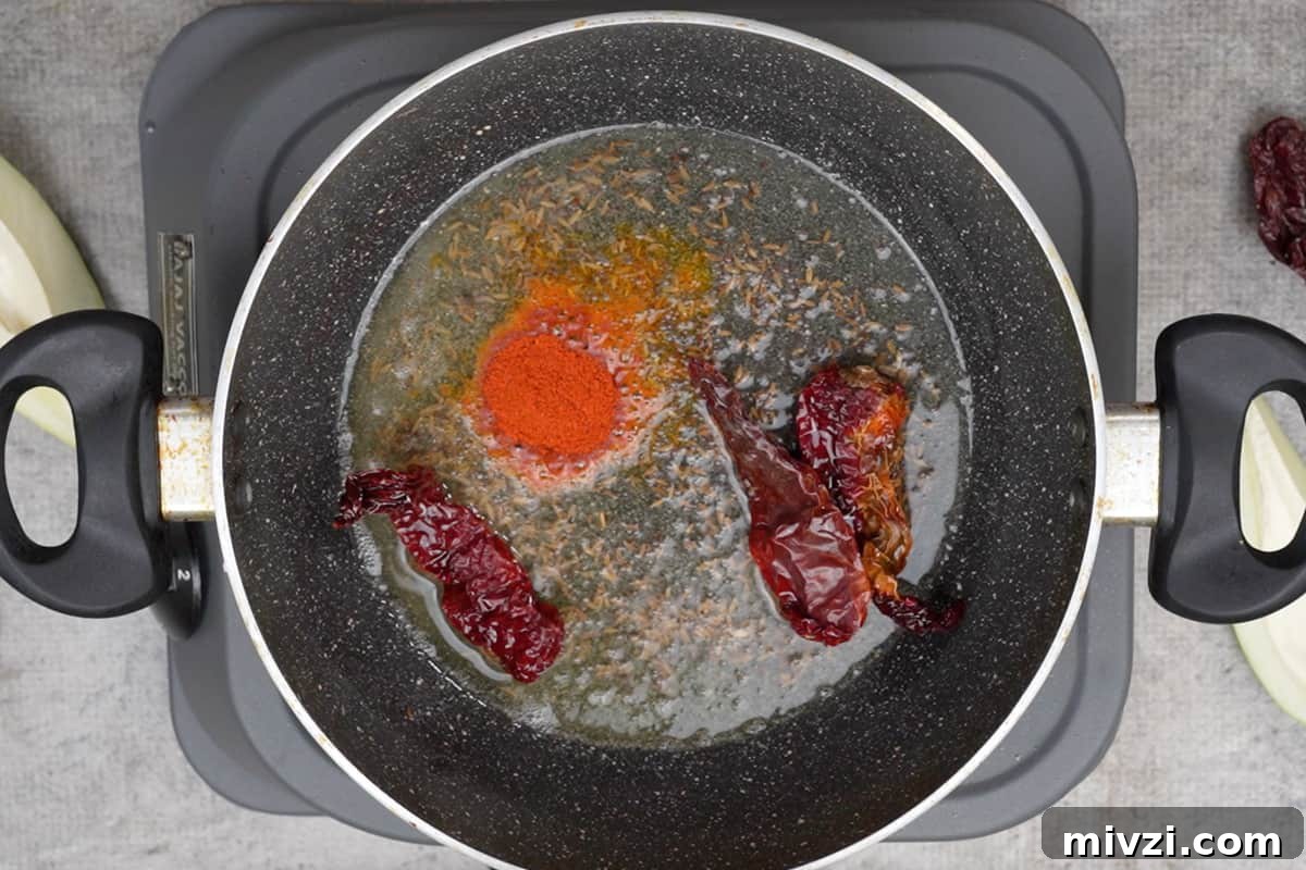 Tangy Raw Mango Dal Recipe for Flavorful Indian Lentils 8 Red chilli powder added to the pan.