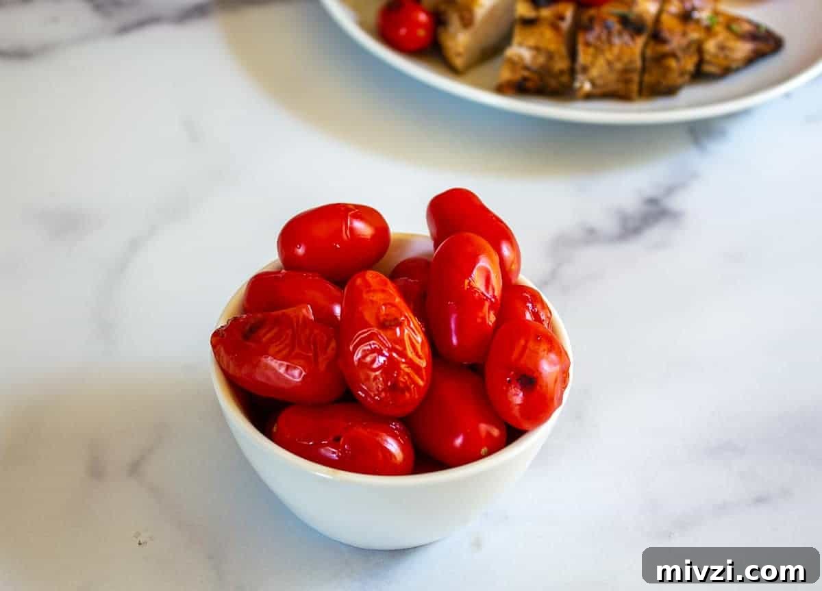 Oven-Roasted Cherry Tomatoes with Garlic and Herbs 3 Grilled cherry tomatoes in a small white bowl.
