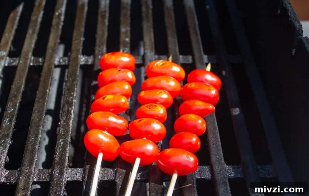 Oven-Roasted Cherry Tomatoes with Garlic and Herbs 7 Cherry tomatoes cooking on a gas barbecue grill.