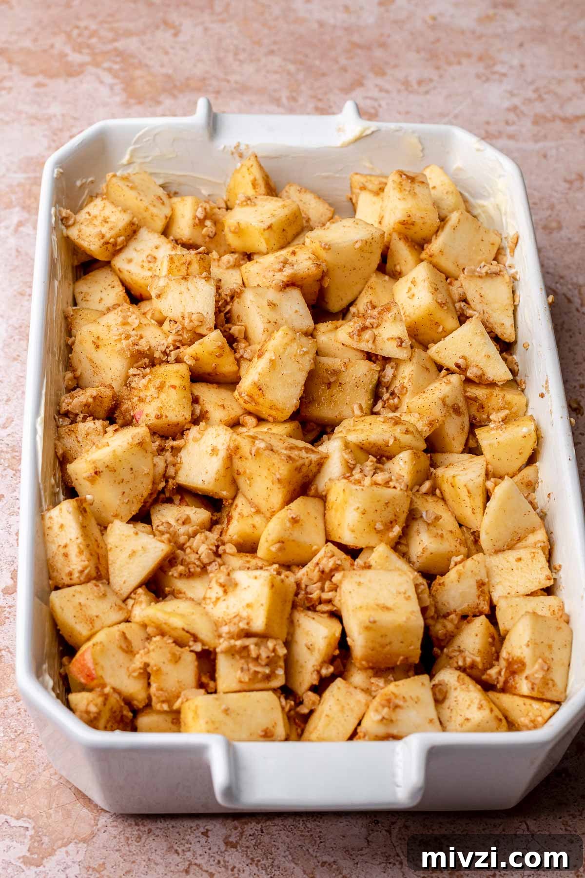 Cinnamon apples in a buttered casserole dish.