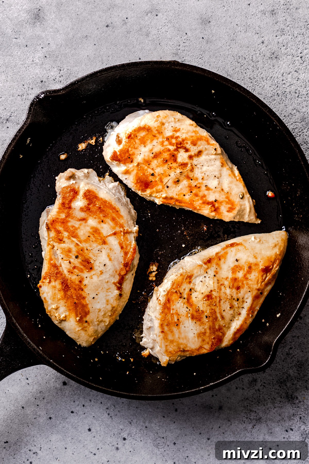 Searing chicken in a skillet for Tuscan chicken. 