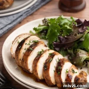 Balsamic-Marinated Chicken Breasts for Juicy Weeknight Meals 9 sliced balsamic marinated chicken breast on an ivory plate with a green salad