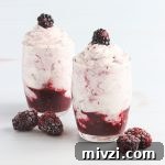 A fruit and cream dessert with blackberries.