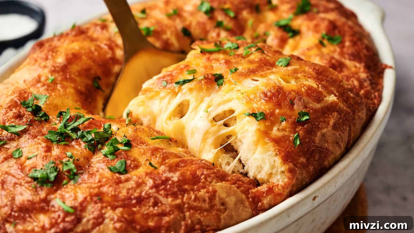 35 Comforting Casserole Recipes to Rely on Tonight 3 A golden-brown baked dish with melted cheese and chopped herbs, being served with a spoon from an oval white casserole dish.