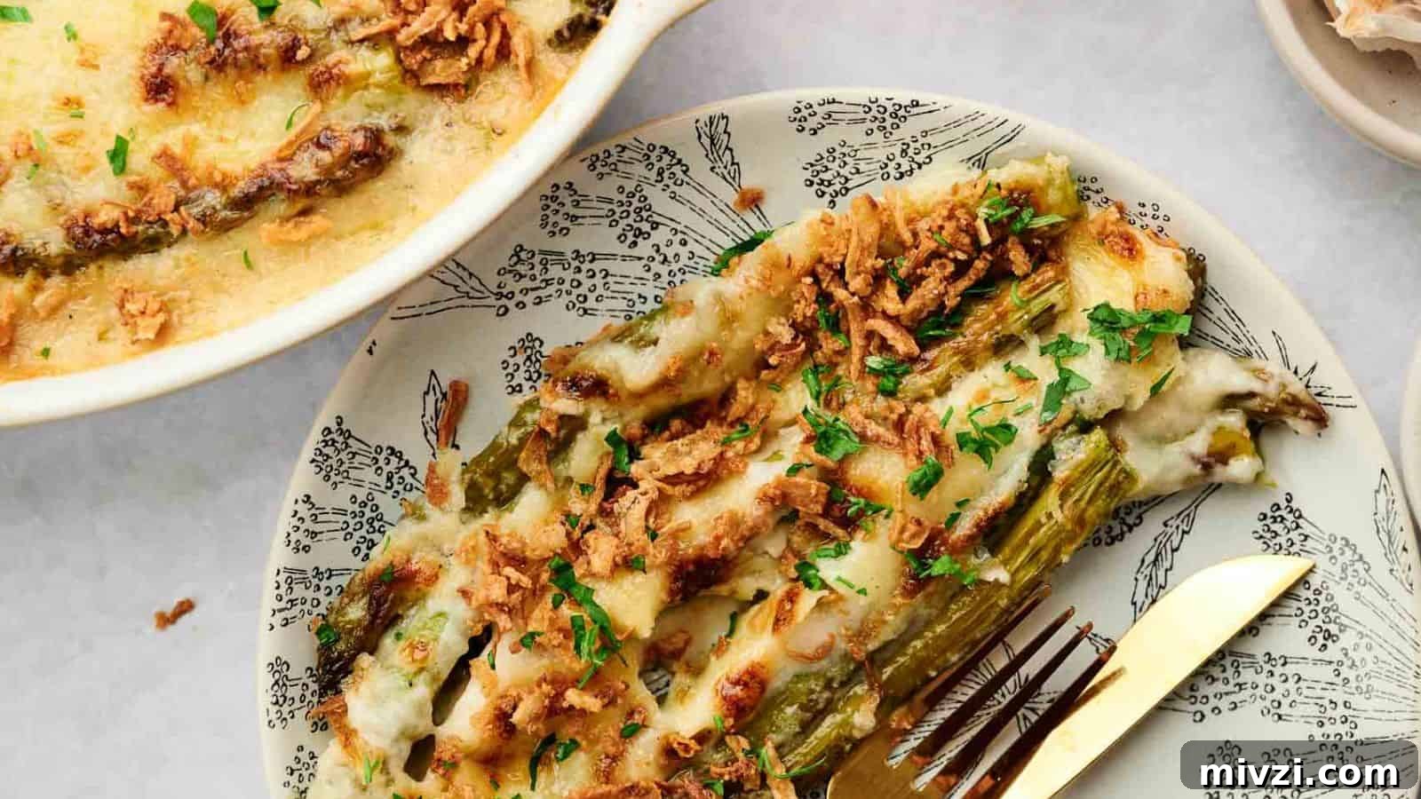 35 Comforting Casserole Recipes to Rely on Tonight 31 Cheesy asparagus casserole on a plate with a fork.