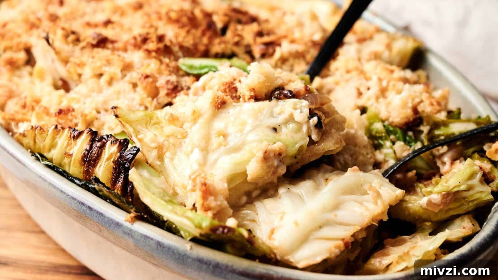 35 Comforting Casserole Recipes to Rely on Tonight 7 A close-up of a baked casserole dish filled with creamy cabbage gratin, topped with a golden breadcrumb crust, with a serving spoon partially visible.