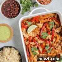 oven baked fajitas in a white baking dish with fajita ingredients in separate bowls around fajita bake
