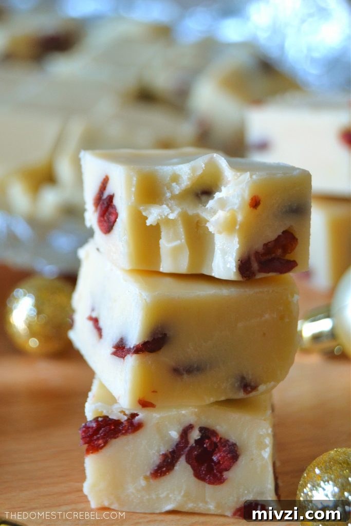 Creamy White Chocolate Cranberry Fudge Recipe 5 Trio of white chocolate cranberry fudge stacked with one piece missing a bite