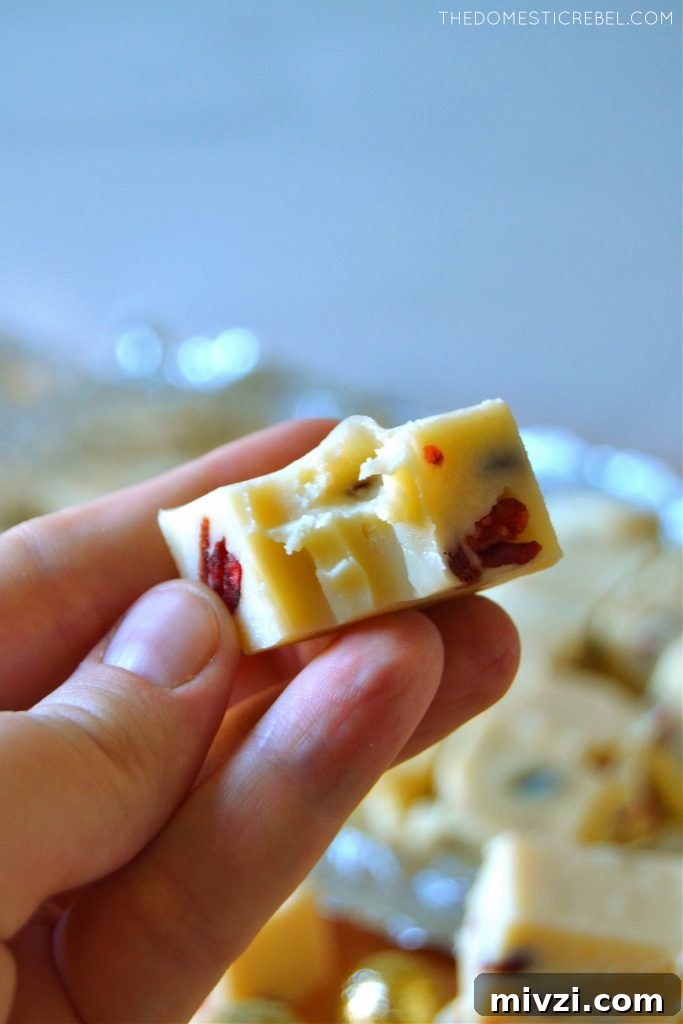 Author holding a piece of white chocolate cranberry fudge