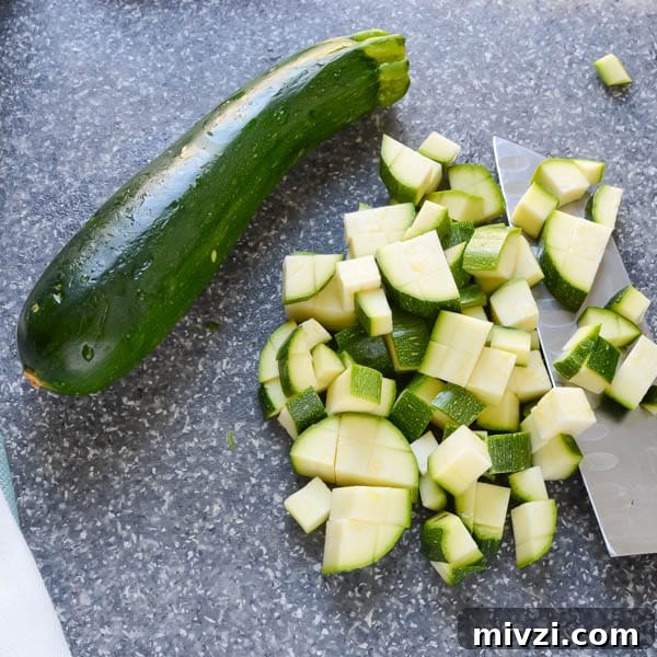 Confetti Corn: Colorful Baked Corn Recipe with Rainbow Veggies 4 zucchini and knife.