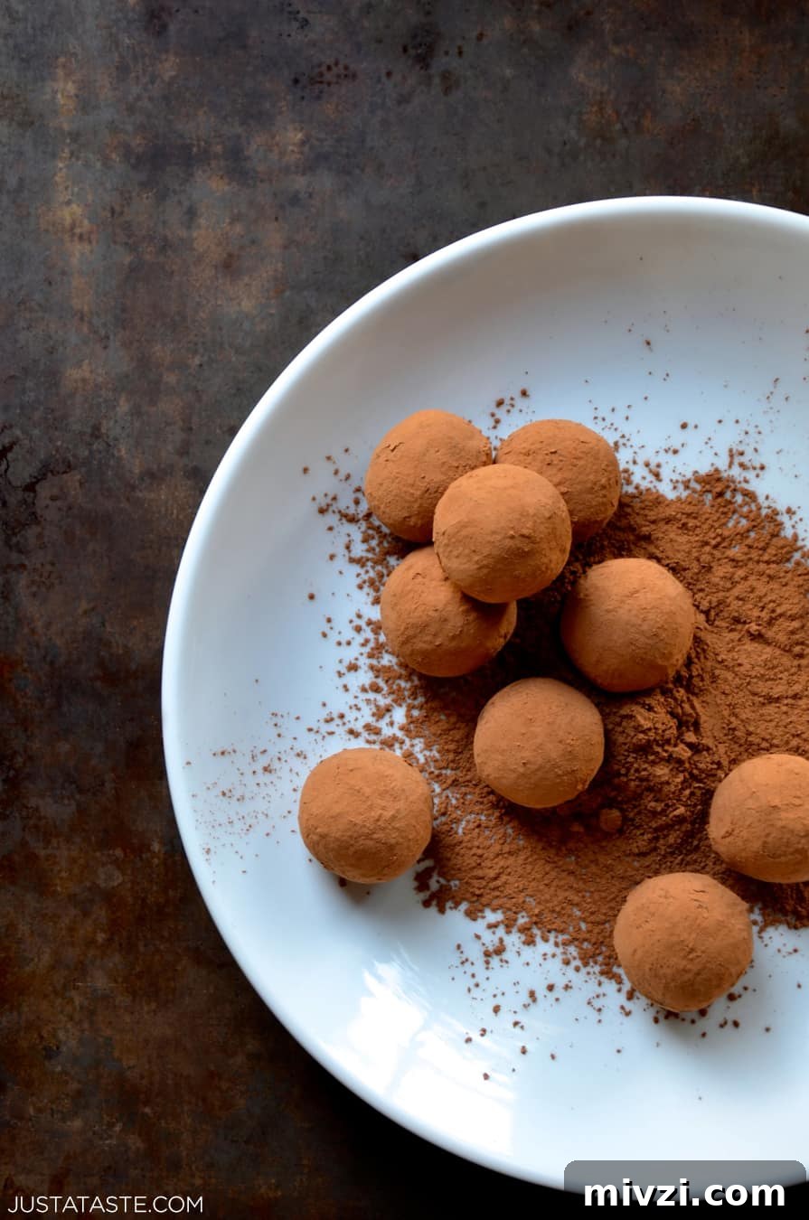 Romantic Valentine’s Day Dessert Ideas and Recipes 14 Chocolate truffles and cocoa powder on a white plate.
