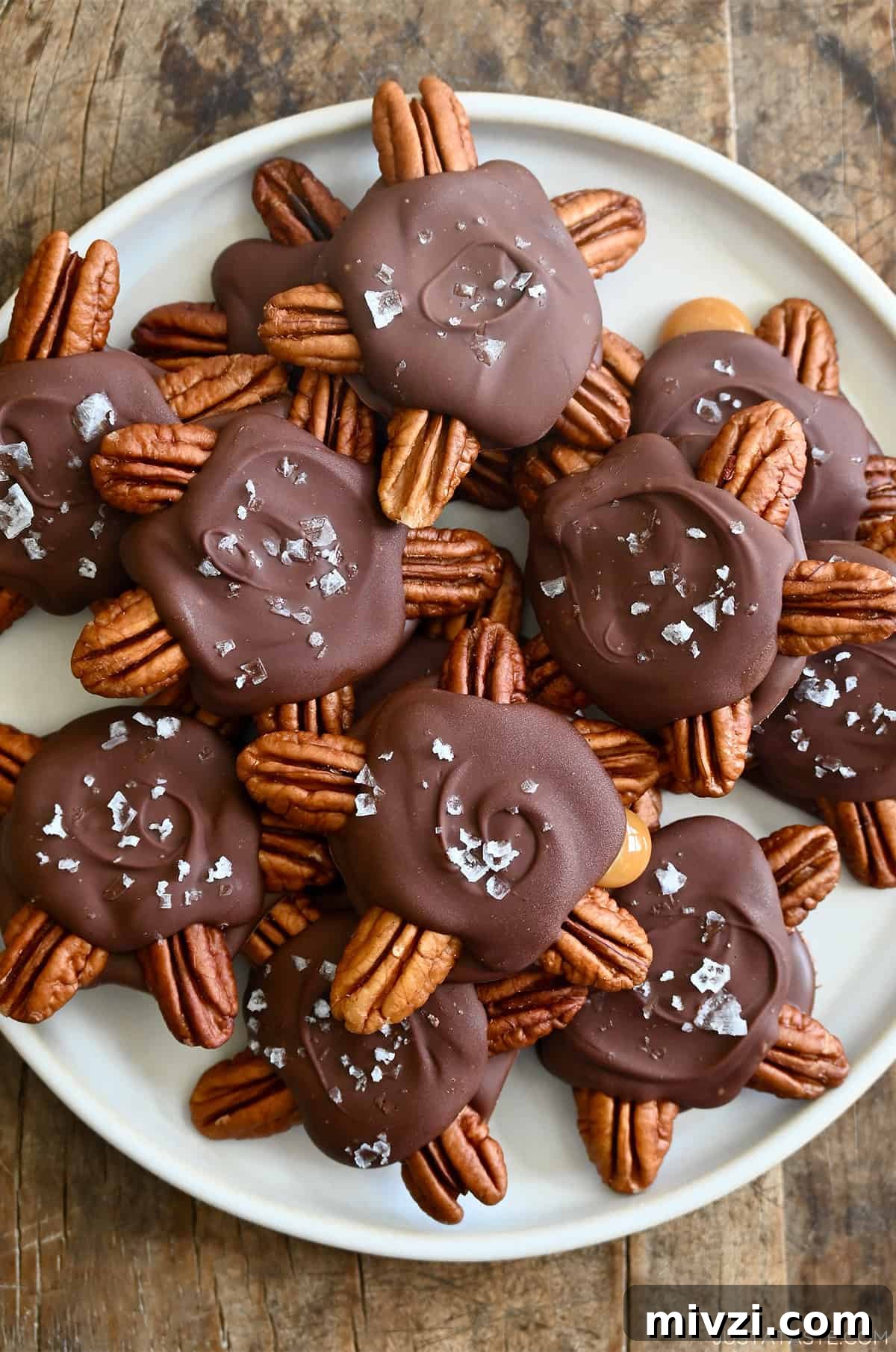 Romantic Valentine’s Day Dessert Ideas and Recipes 19 Homemade turtle candies topped with flaky sea salt on a white plate.