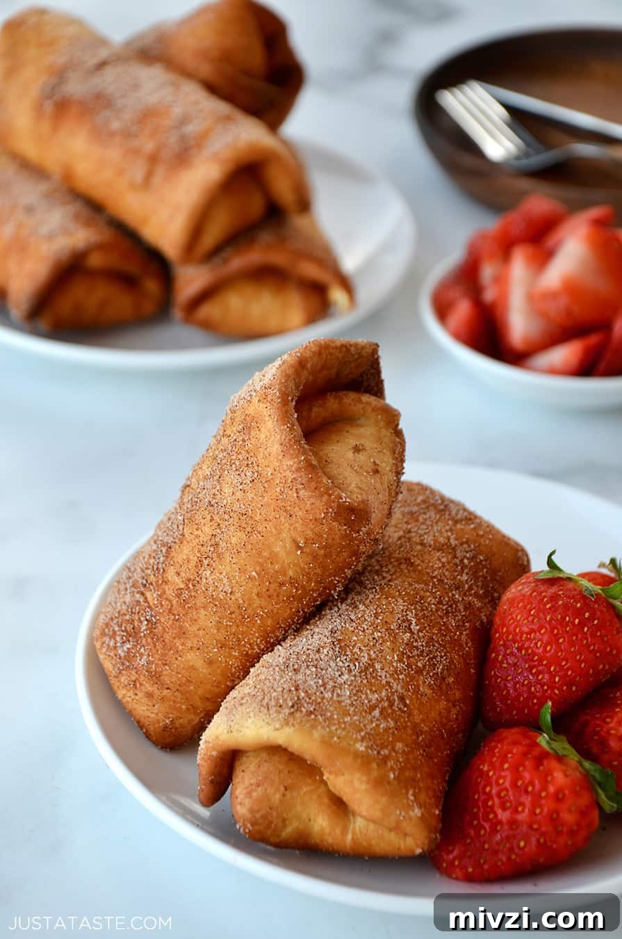 Romantic Valentine’s Day Dessert Ideas and Recipes 21 Two Strawberry Cheesecake Chimichangas on a white plate with fresh strawberries
