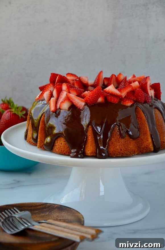 Romantic Valentine’s Day Dessert Ideas and Recipes 23 A cake with chocolate frosting and strawberries on a white cake stand