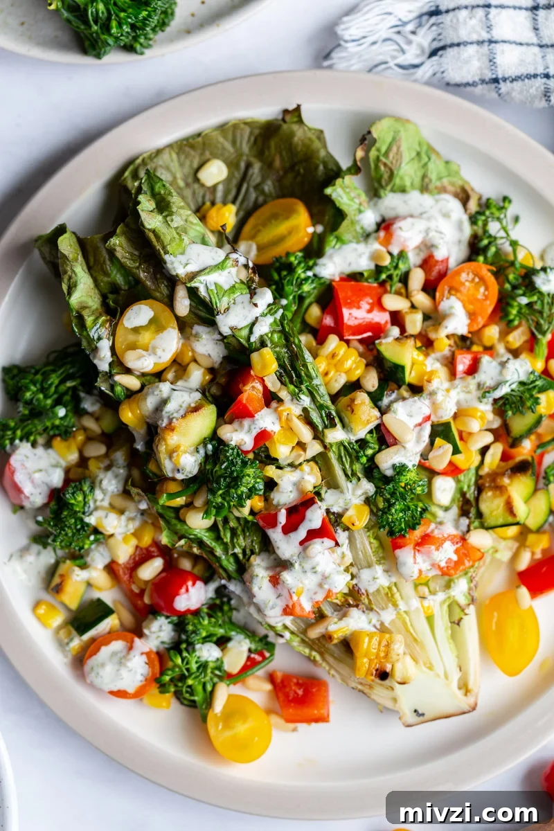 grilled romaine lettuce topped with mixed veggies and a white salad dressing
