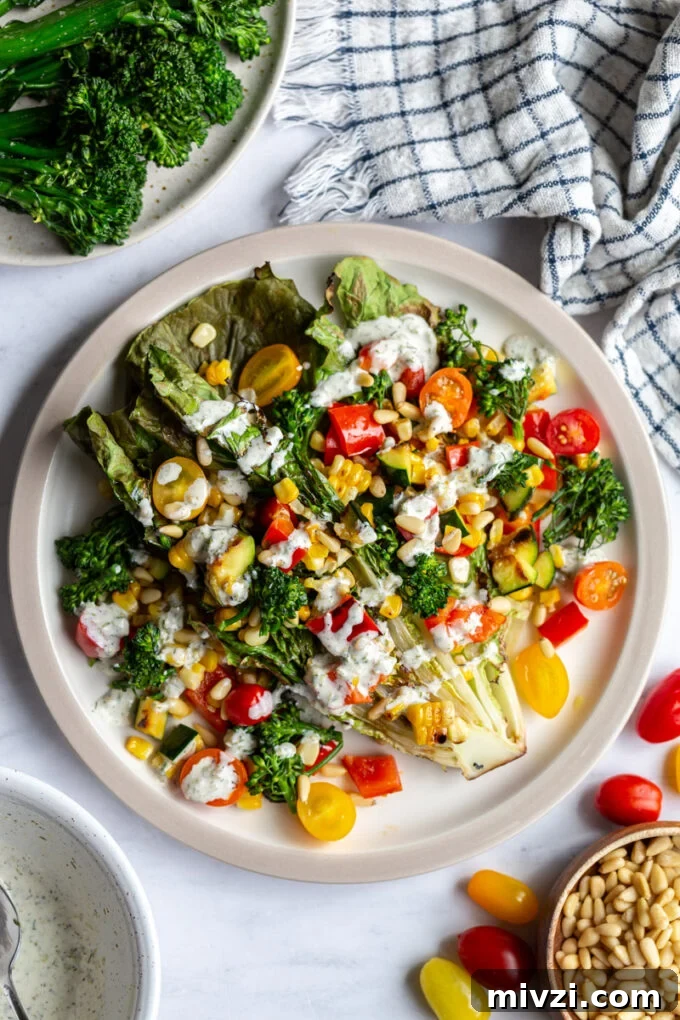 grilled romaine lettuce topped with mixed veggies and a white salad dressing
