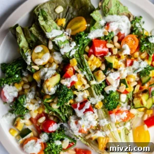 grilled romaine lettuce topped with mixed veggies and a white salad dressing