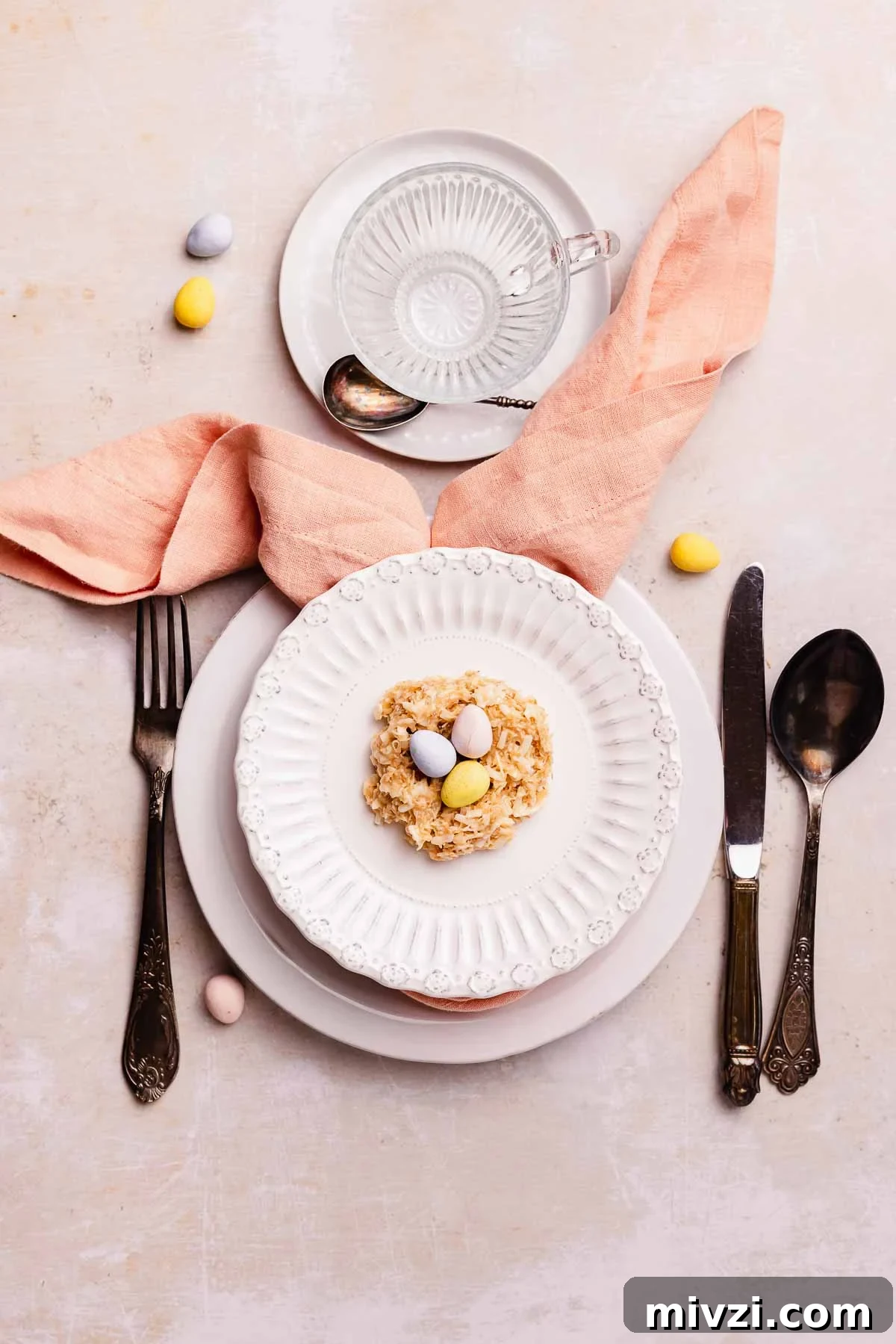 table setting for easter with birds nest cookie and bunny ear napkin fold