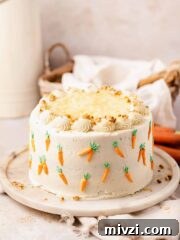 carrot cake with pineapple on cake stand with mini piped carrots on sides