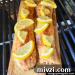 Creative Recipes for Leftover Salmon: 25 Ways to Reuse Fillets 5 Grilled salmon on a cedar plank cooking on a gas grill