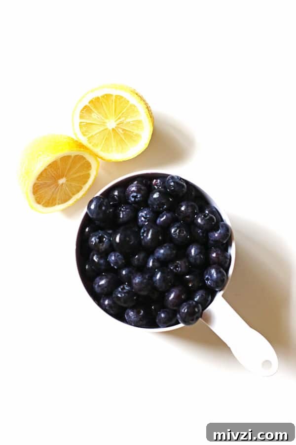 Refreshing Blueberry Lemon Smoothie Recipe for Morning Energy 4 Lemon sliced in half and blueberries in a white measuring cup