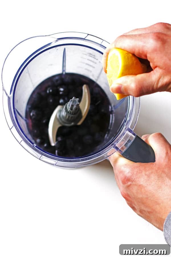 Refreshing Blueberry Lemon Smoothie Recipe for Morning Energy 5 Blueberries and water in blender and squeezing a lemon over the blender