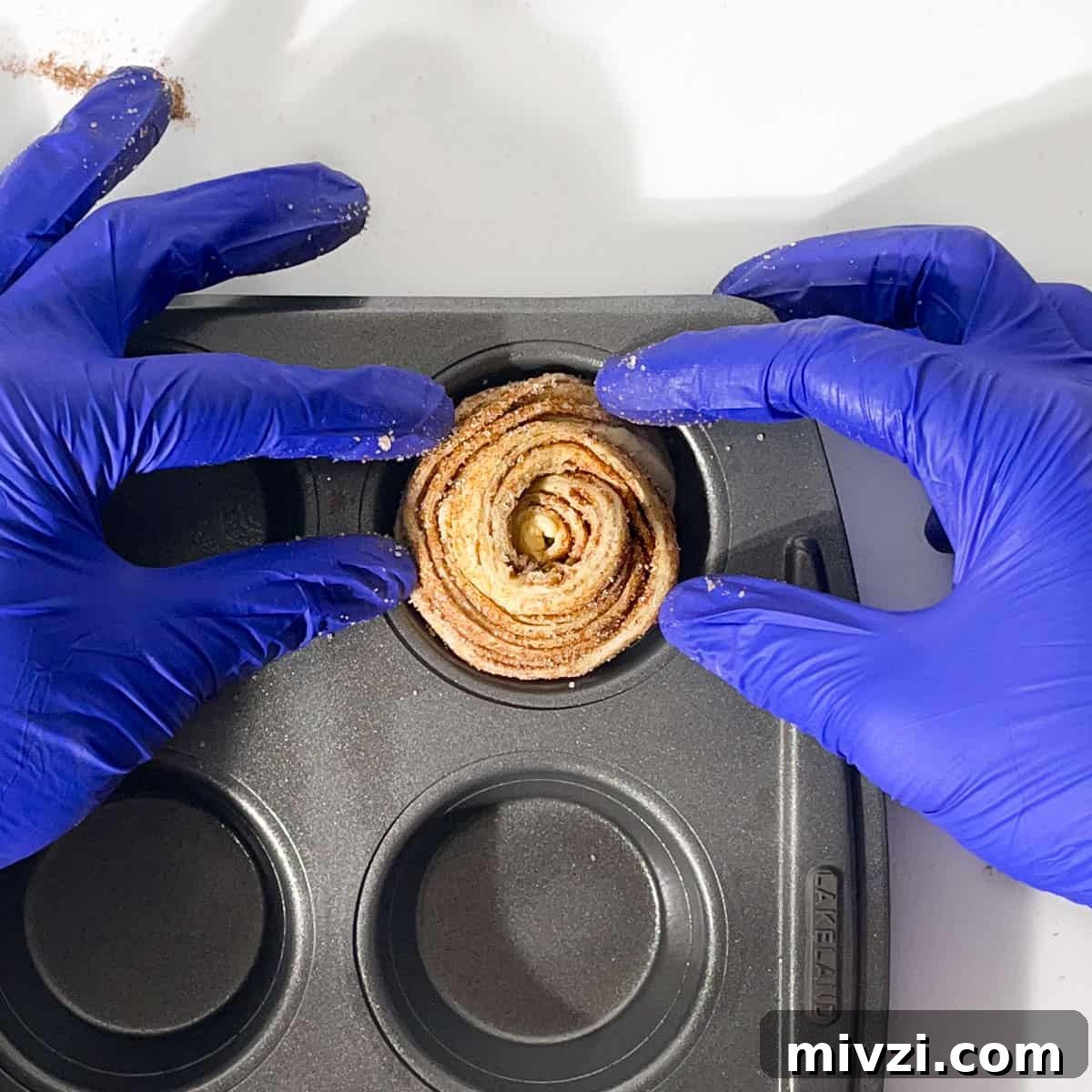 Canned Crescent Dough Cruffins Recipe: Flaky Homemade Pastry in Minutes 17 Placing one cruffin roll into the hole of a muffin tin.