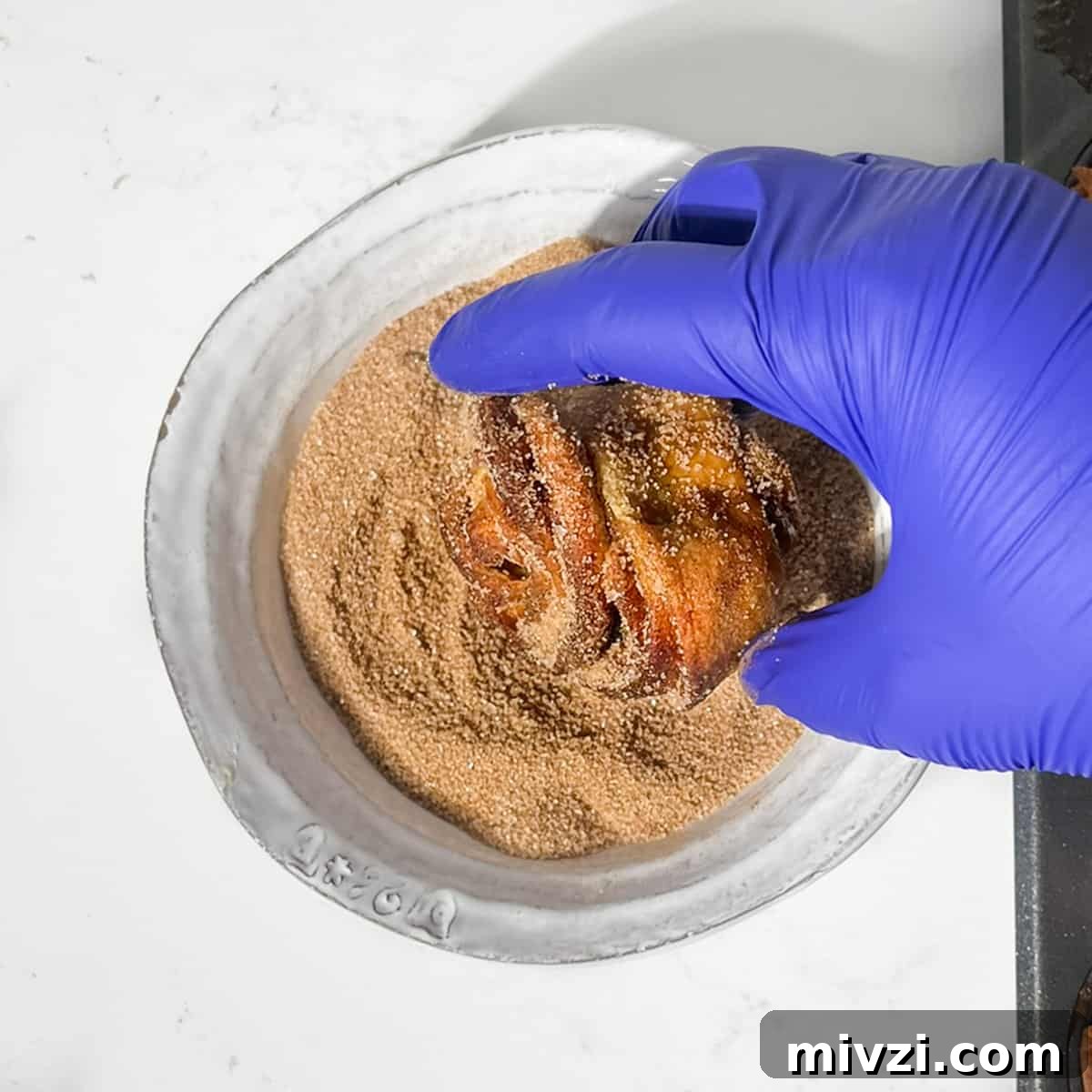 Canned Crescent Dough Cruffins Recipe: Flaky Homemade Pastry in Minutes 19 Rolling a cruffin in cinnamon sugar.