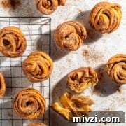 Canned Crescent Dough Cruffins Recipe: Flaky Homemade Pastry in Minutes 20 Cruffins scattered on a white background sprinkled with cinnamon sugar.