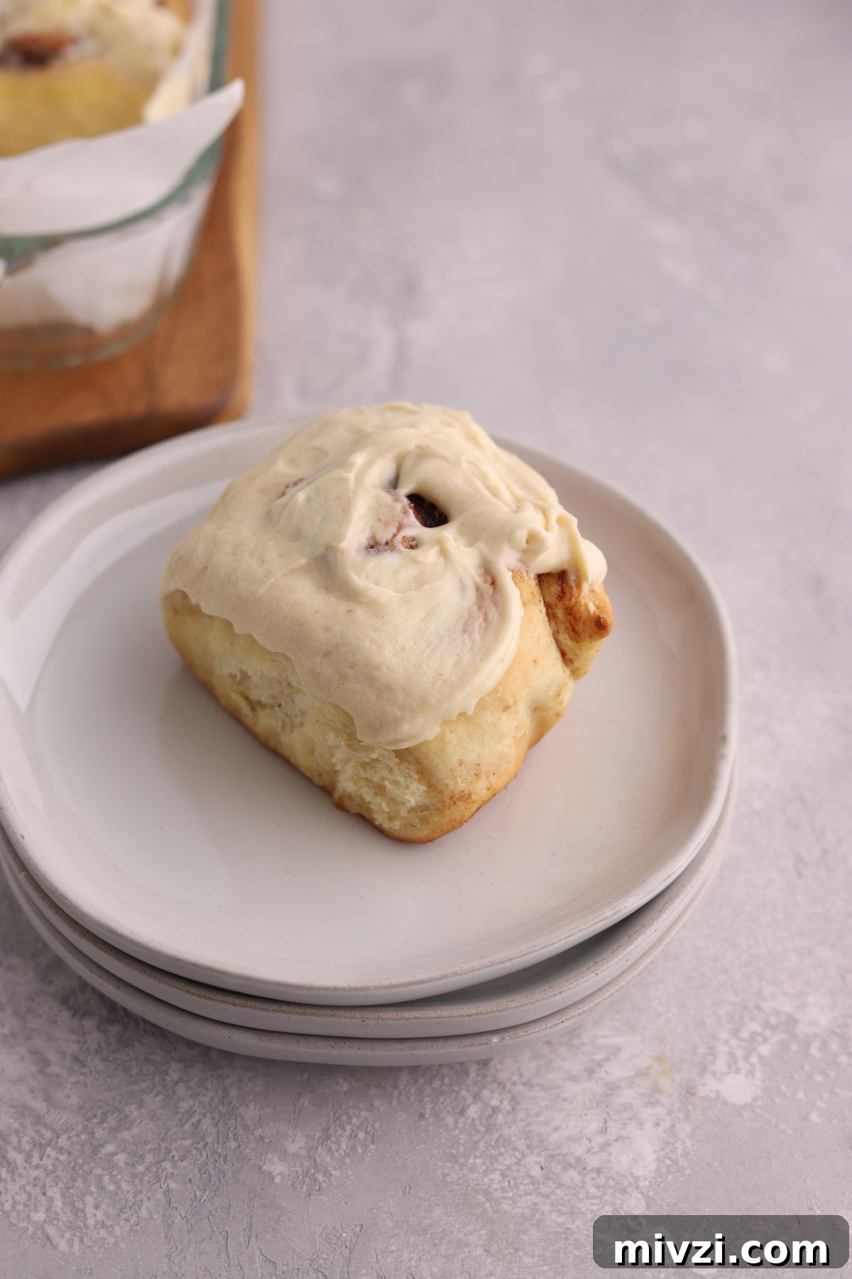 Brown Butter Cinnamon Rolls with Gooey Caramelized Swirl 3 A cinnamon rolls with icing on top on some plates.