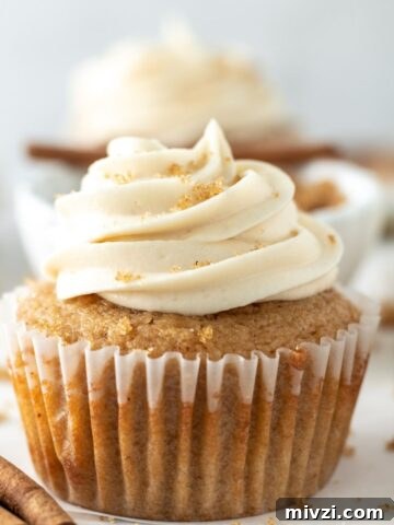 A cupcake topped with a swirl of frosting sprinkled with brown sugar.