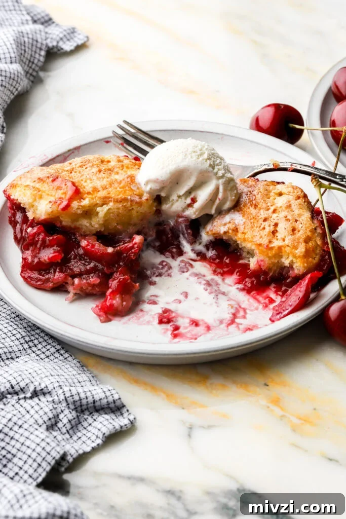 cherry cobbler on a plate with ice cream