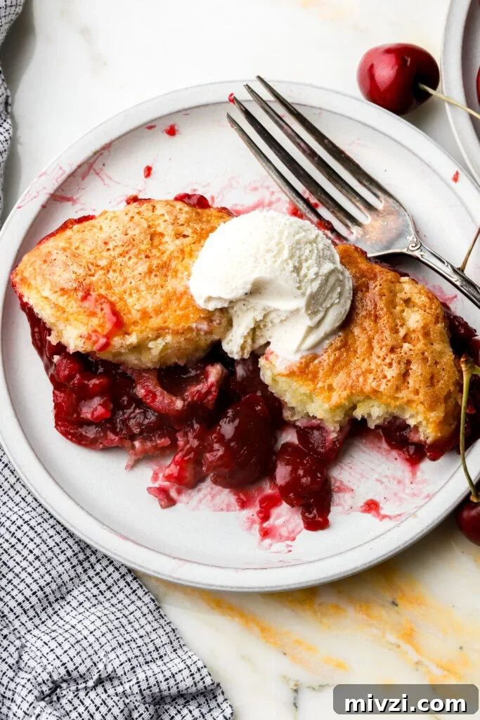 cherry cobbler on a plate with ice cream on top