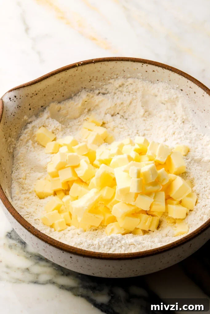 all dry ingredients in a bowl with cold cubed butter on top
