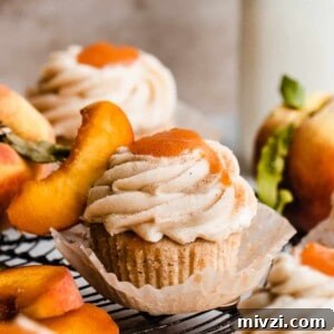 Peach Cupcakes with Cinnamon Cream Cheese Frosting — Summer Dessert Recipe 12 Peach cupcakes topped with frosting and peach filling.