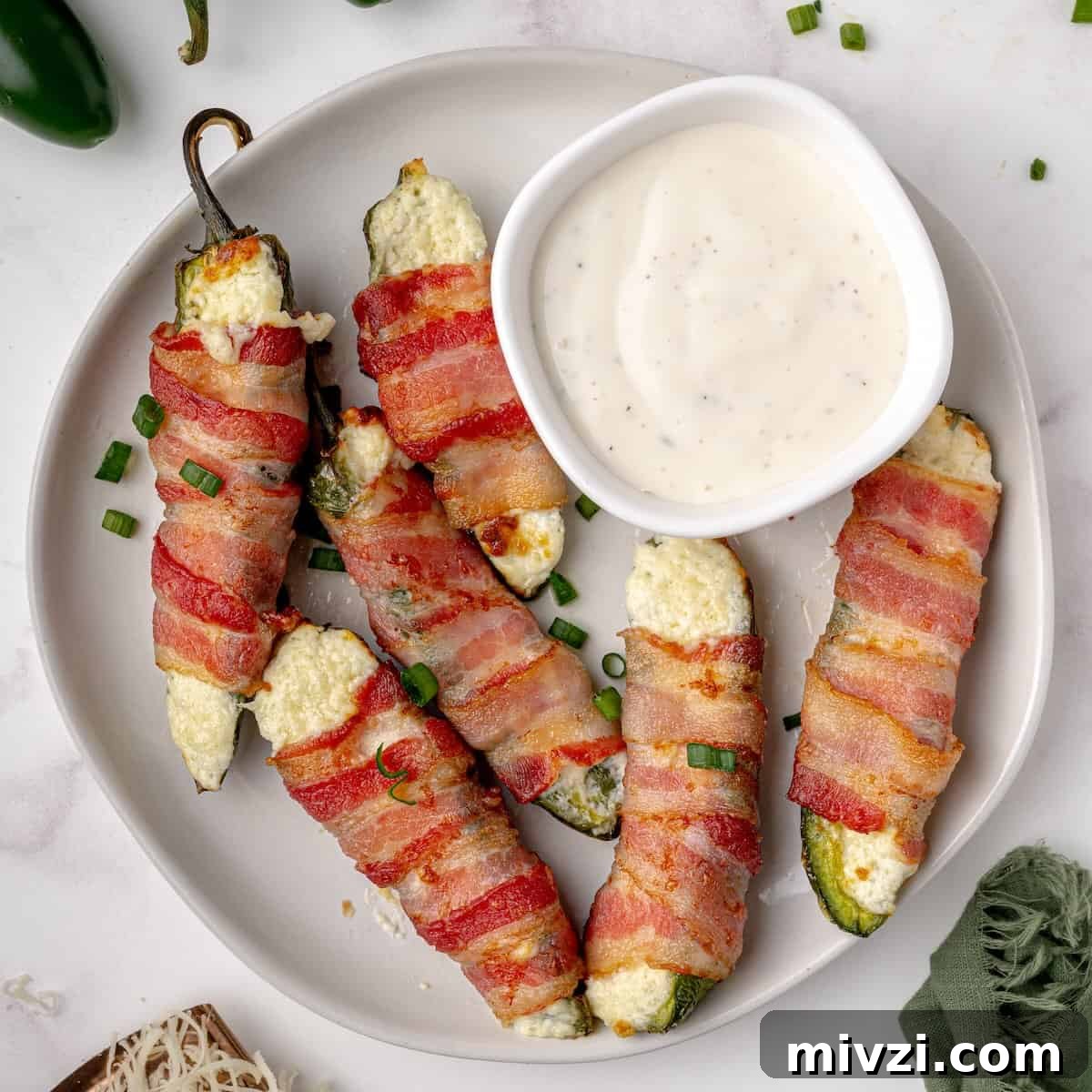 Homemade jalapeño poppers served on a platter with ranch for dipping.