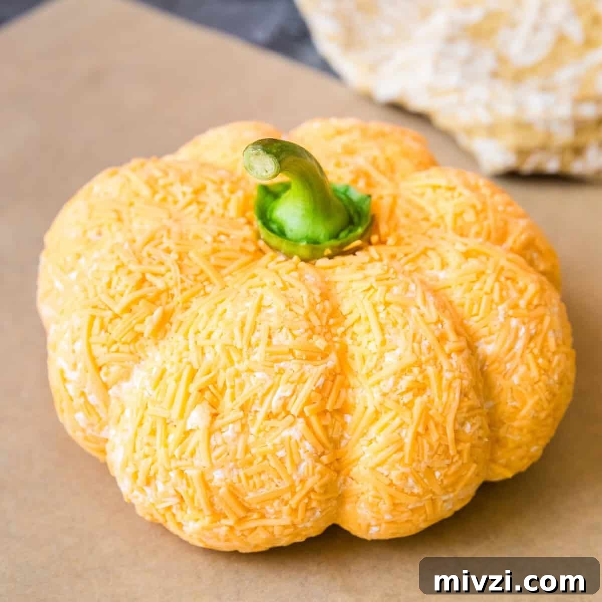 A cheddar ranch cheese ball shaped like a pumpkin.