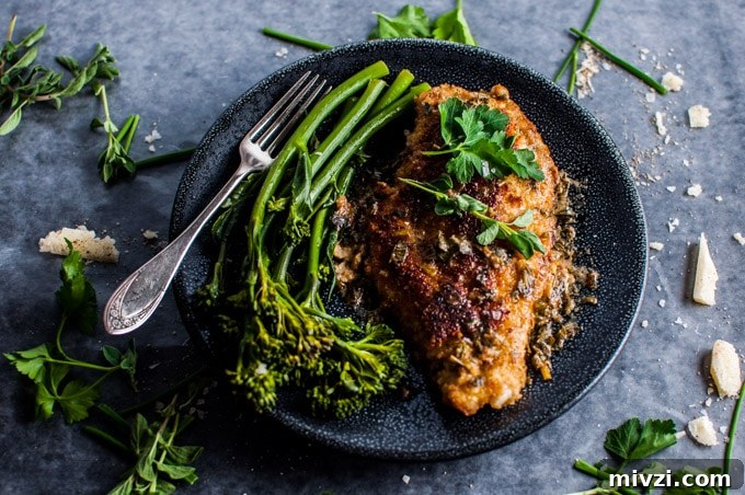 Parmesan Crusted Chicken with Fresh Herb Sauce 3 plate with parmesan chicken breasts with herb sauce on a plate with broccolini