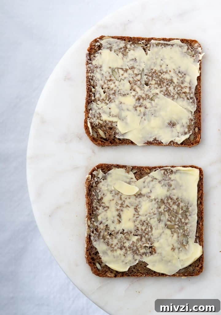 Two pieces of buttered rye bread on a plate