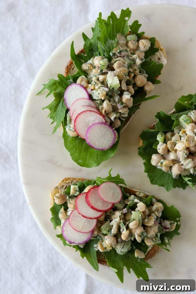Open sandwiches with chickpea salad, radishes and lettuce on a plate