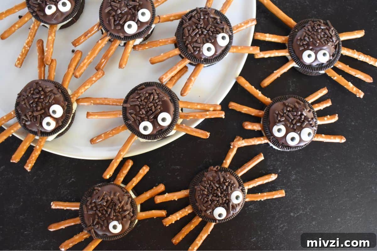 Oreo Spider Cookies: Fun Halloween Treat Recipe 3 Overhead photo of Oreo Cookie spiders with pretzel legs on a black background.