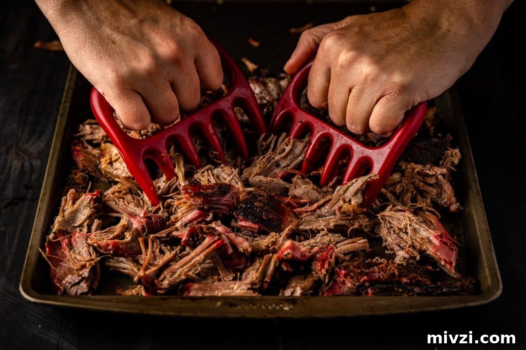 Meat shredder claws shredding smoked lamb shoulder.