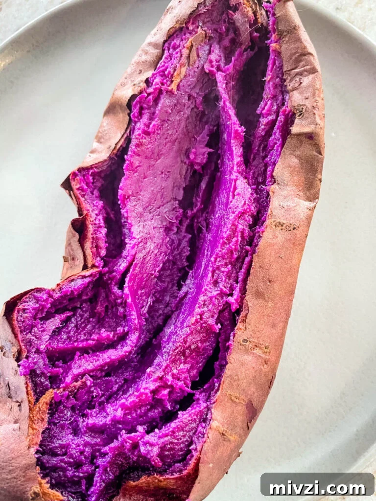 How to Cook Purple Sweet Potatoes: Simple Recipes & Techniques 4 Stokes purple sweet potato fully cooked and sliced open on a plate