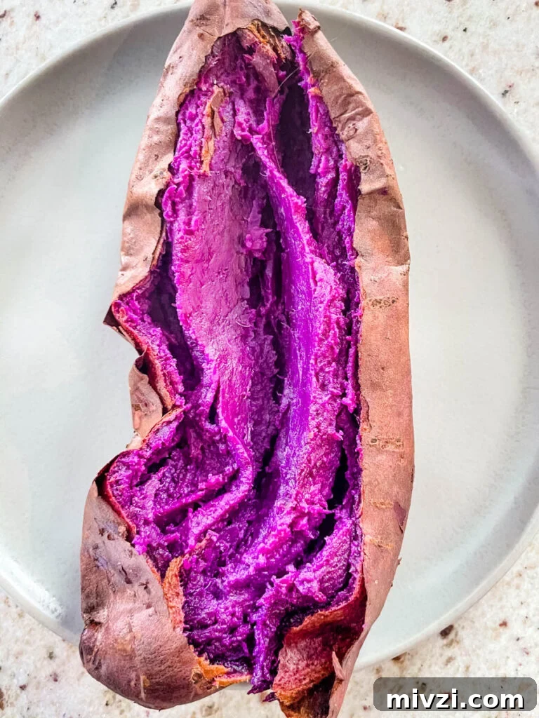 How to Cook Purple Sweet Potatoes: Simple Recipes & Techniques 7 Stokes purple sweet potato fully cooked and sliced open on a plate