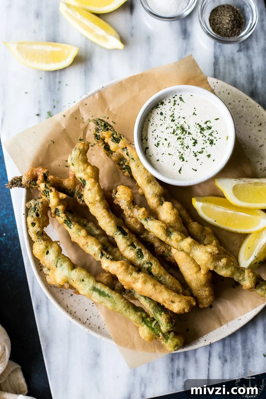 Crispy Asparagus Tempura with Tangy Horseradish Cream Sauce 2 Overhead photo of asparagus tempura with horseradish cream sauce on a plate on a marble board