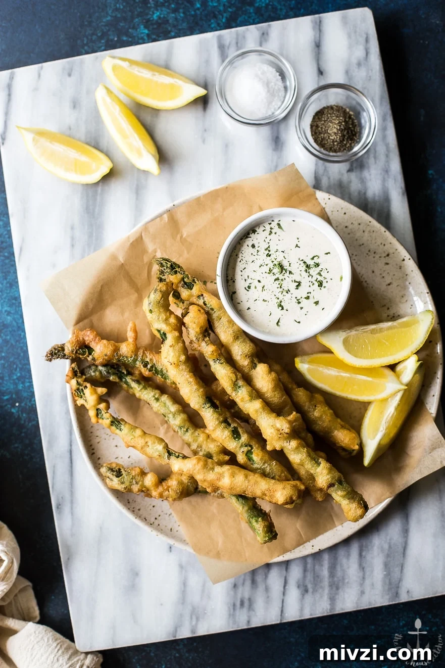 Crispy Asparagus Tempura with Tangy Horseradish Cream Sauce 3 Overhead photo of asparagus tempura with horseradish cream sauce on a plate on a marble board