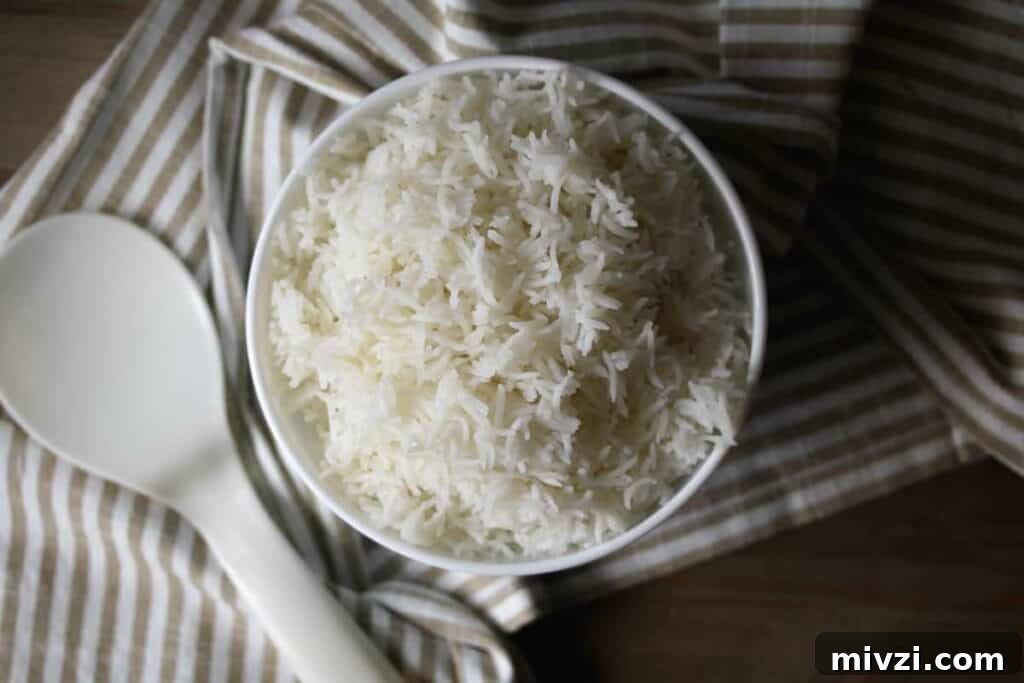 White rice in a white bowl on a striped towel