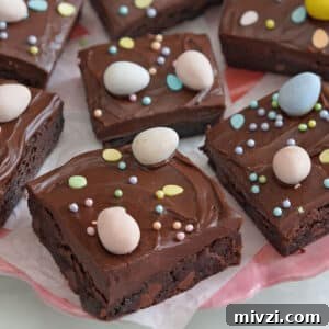 Easter Chocolate Push-Up Pops: Festive Treats for Kids 13 Easter Egg Brownies on a white plate with Cadbury mini eggs on top and next to it.